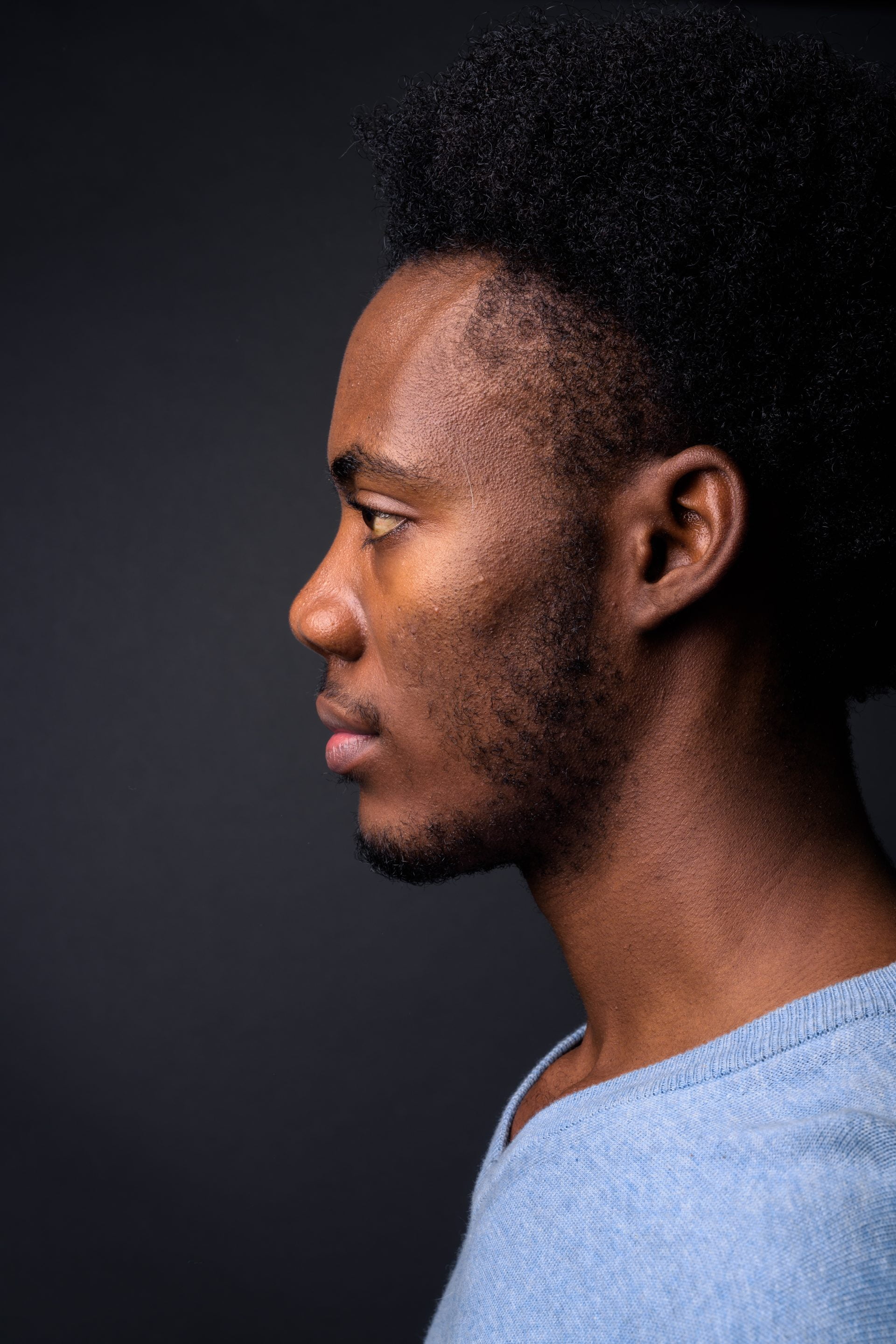 Face of young handsome African man against gray background
